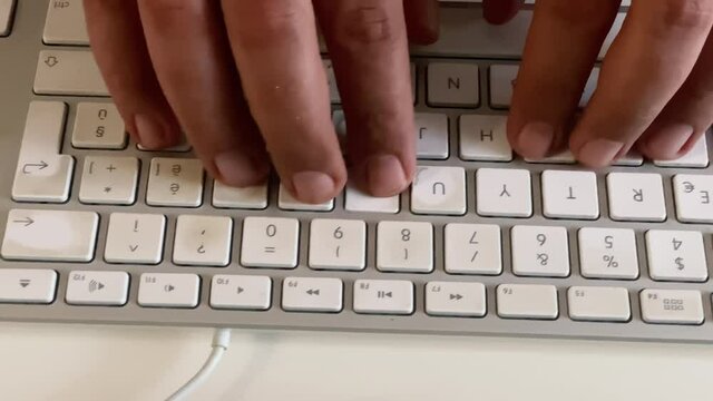 male hands typing on a computer keyboard