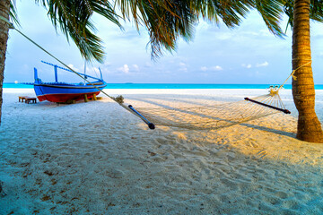 Empty hammock between palms trees at sandy beach