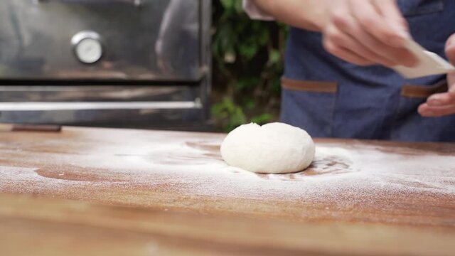 Chef preparando la masa para pizza en una cocina al aire libre