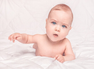 Sweet little baby boy sitting on his tummy, white background