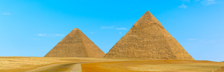 Fototapeta na wymiar Pyramids at Giza, Egypt protrude majestically into a blue cloudless sky in summer