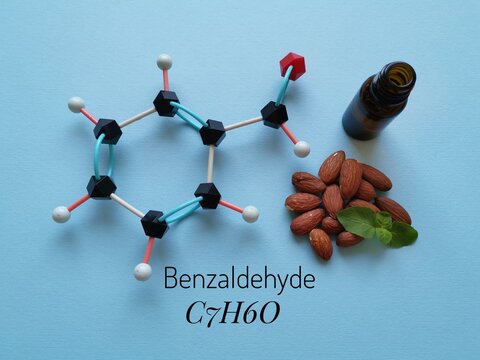 Molecular structure model of benzaldehyde molecule with almond oil. It is an aromatic aldehyde and one of the most industrially useful; a colorless liquid with a characteristic almond-like odor.