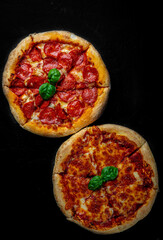 Pepperoni Pizza and Pizza with Mozzarella cheese, Tomatoes, pepper, olive, Spices and Fresh basil. Pizza Margherita or Margarita on Dark grey black slate background