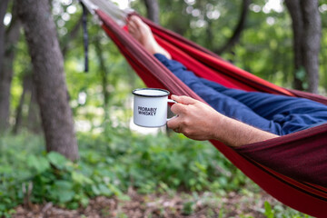 Man relaxing in a hammock with a beverage - Powered by Adobe
