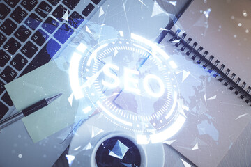 Double exposure of SEO drawing over study table background with computer. Concept of search. Top view.