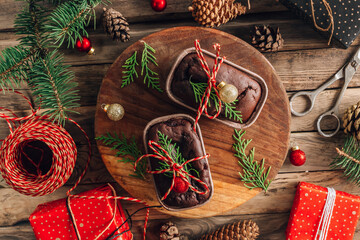 Closeup of chocolate fudge brownies on a plate with Christmas decorations in background