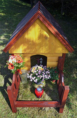 Fototapeta na wymiar Wooden dog house as a monument on the grave