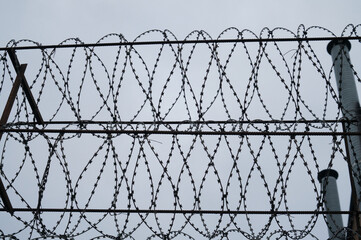 barbed wire silhouette at dusk against cloudy sky
