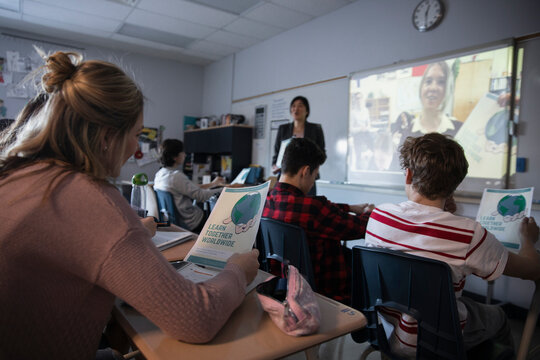 High school students and teacher watching global video in classroom