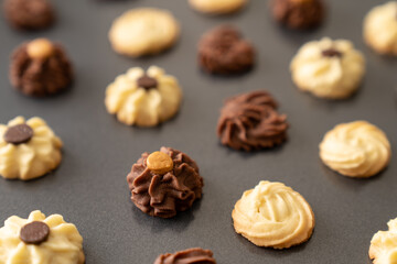 Homemade assorted chocolate bite size butter cookies on baking tray