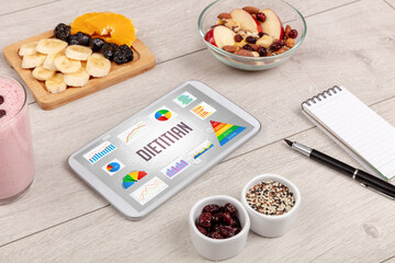 Organic food and tablet pc showing DIETITIAN inscription, healthy nutrition composition