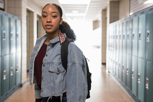 Portrait confident high school girl student in corridor