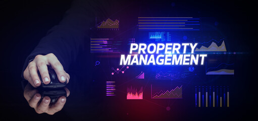 hand holding wireless peripheral with PROPERTY MANAGEMENT inscription, cyber business concept