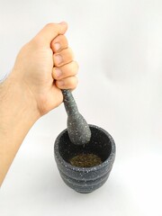 grinding oregano with stone mortar