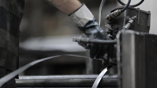 Manufacture of steel products. Tube rolling plant. The packer straps the pipes with metal tape