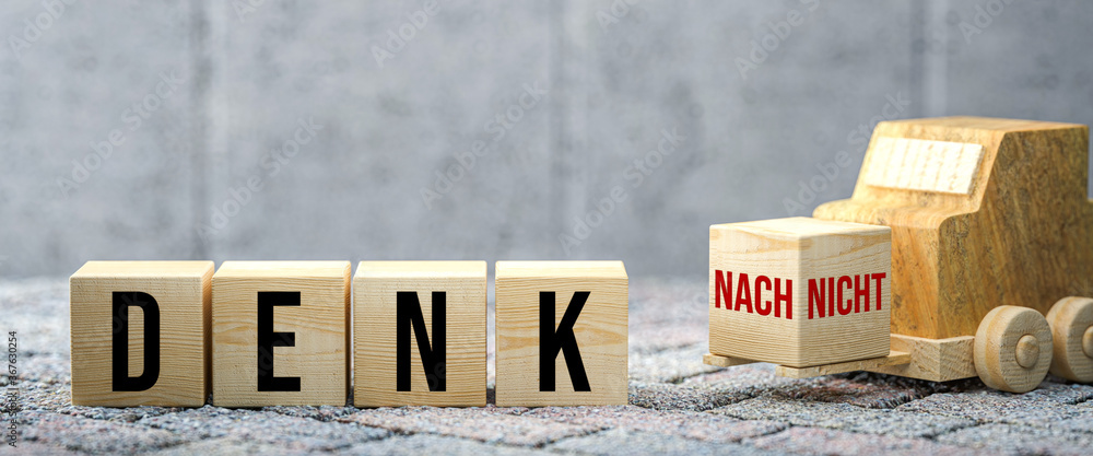 Wall mural wooden forklift is transporting off a cube that completes a german message to either think about it 