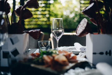 tableware Glasses, flower fork, knife served for dinner in restaurant with cozy interior