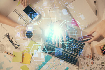 Double exposure of man's hands typing over computer keyboard and social network theme hologram drawing. Top view. People connection web concept.