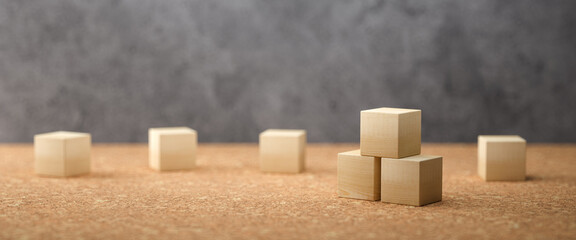 empty wooden cubes for own messages and icons on cork floor in front of a concrete wall