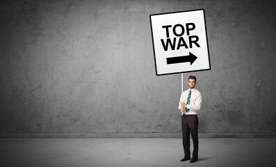 Obraz premium business person holding a traffic sign with TOP WAR inscription, new idea concept