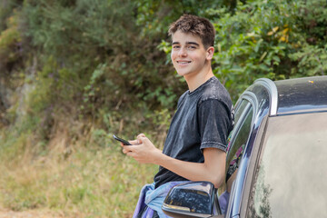 Obraz premium young boy with mobile phone and car outdoors