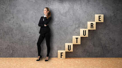 businesswoman standing beside wooden cubes formed as a stair with the word FUTURE on concrete background