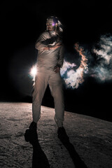 A man in white flax costume and colored smoke. Dark background