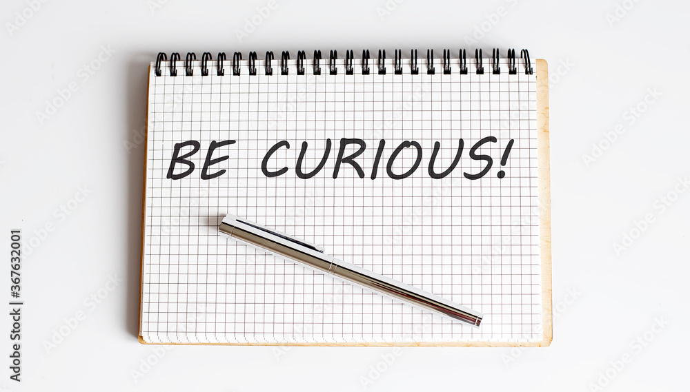 Poster be curious! text written on a notebook with pen