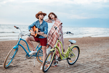 Obraz premium Two attractive people are standing with their bicycles. Boy is looking at the girl