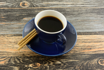 Demi-tasse cup of coffee with kona coffee flavored biscuit snacks on table