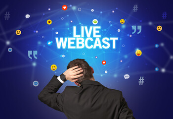 Rear view of a businessman with LIVE WEBCAST inscription, social networking concept