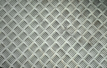 The texture of an aluminum plate with cuts and stripes.