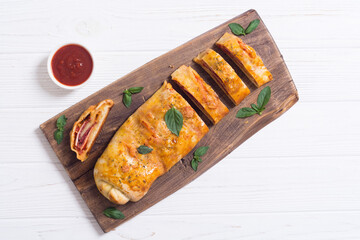 Pizza roll stromboli with cheese salami olives and tomatoes