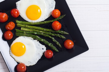 Healthy breakfast with eggs , asparagus and tomatoes