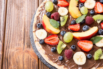Fruit pizza with nut nougat cream , fruit and berries