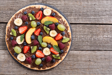 Fruit pizza with nut nougat cream , fruit and berries