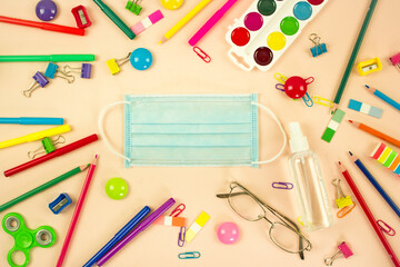 concept of social distance and education in the corona virus pandemic. new school year and knowledge day. protective mask and stationery set