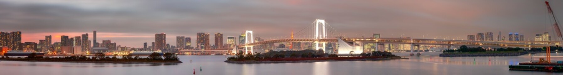 Obraz premium Tokyo Destinations. Famous Rainbow Bridge in Odaiba Island in Tokyo with Line of Skyscrapers in Background.