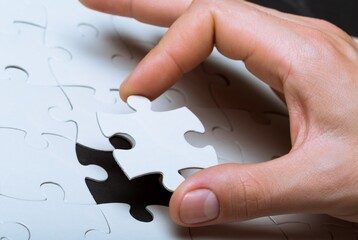 Closeup of a Hand Finishing a Puzzle