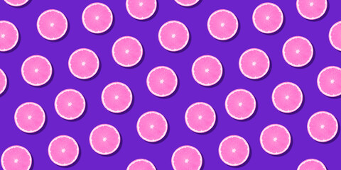 Seamless pattern pink citrus fruit orange lemon lying on violet surface. Colorful fresh citrus slice wallpaper. Creative vivid vibrant color, summer friuts concept. Minimal pop art style