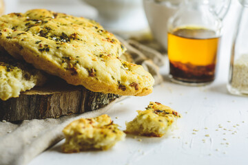 Foccacia, flatbread, some eggs, oil, sesame, white background.