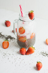 chia seeds and strawberry water, white background.
