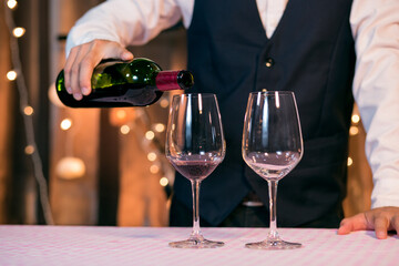 Waitress man pouring wine into glass