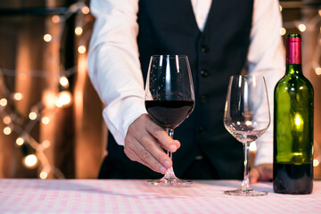 Waitress man pouring wine into glass