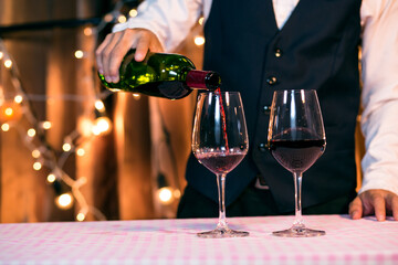 Waitress man pouring wine into glass
