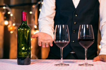 Waitress man pouring wine into glass
