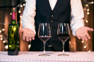 Waitress man pouring wine into glass