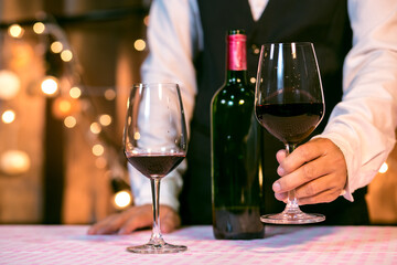 Waitress man pouring wine into glass