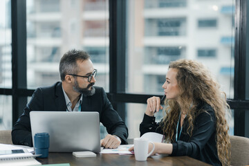 Young manager listening to his colleague explanations in modern co working office.