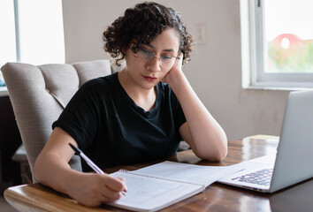 Obraz premium Young woman studying online during quarantine. Working from home.
